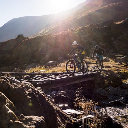 Nate Hills and Francesco Gozio riding across a bridge