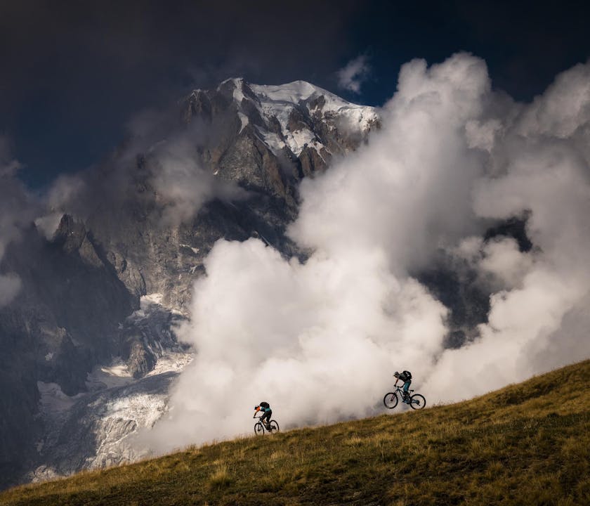 NATE HILLS and FRANCESCO GOZIO riding down a ridge line.