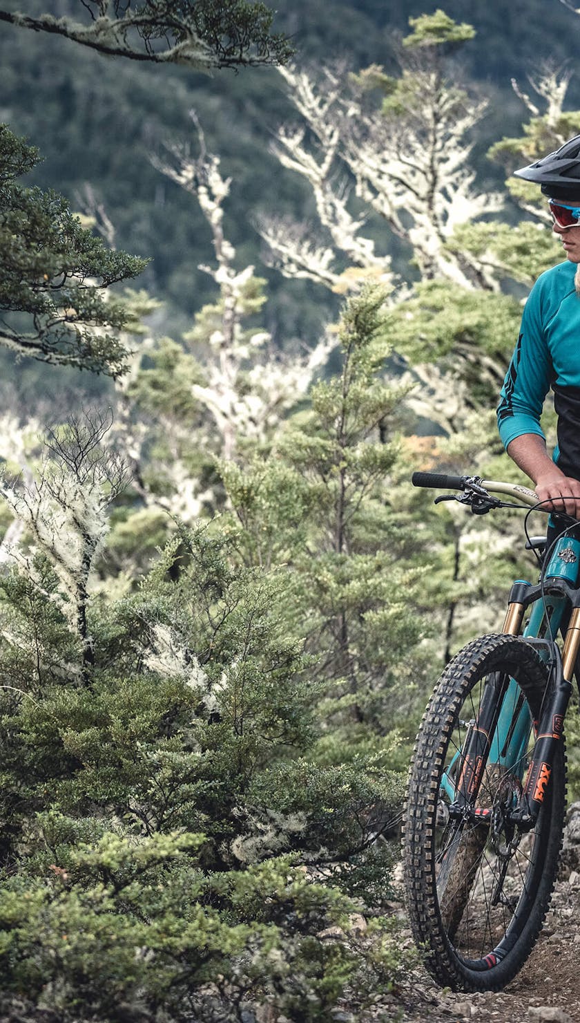 Cody Kelley standing among the trees along side his SB5.5