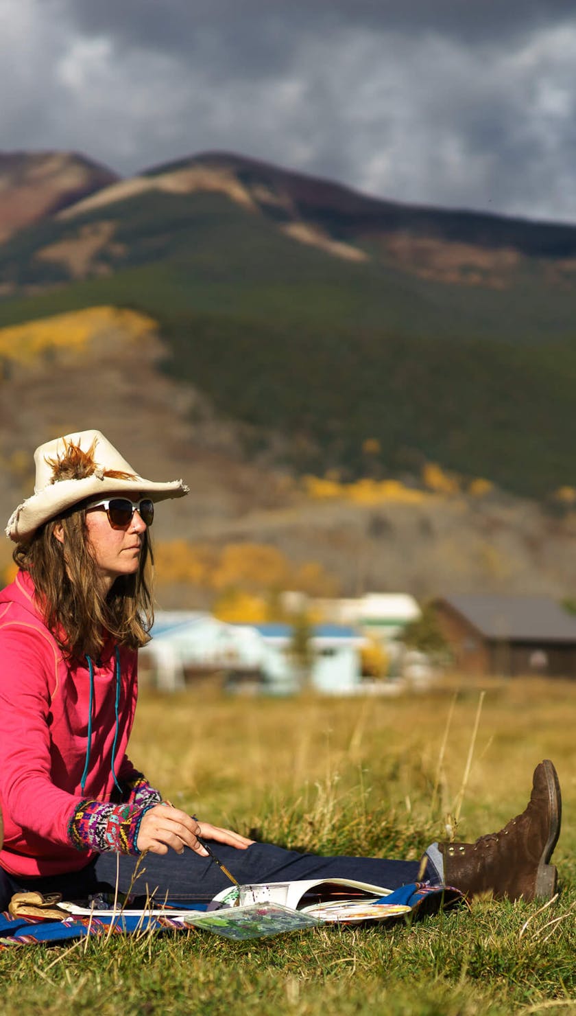 Sarah Uhl painting in a field
