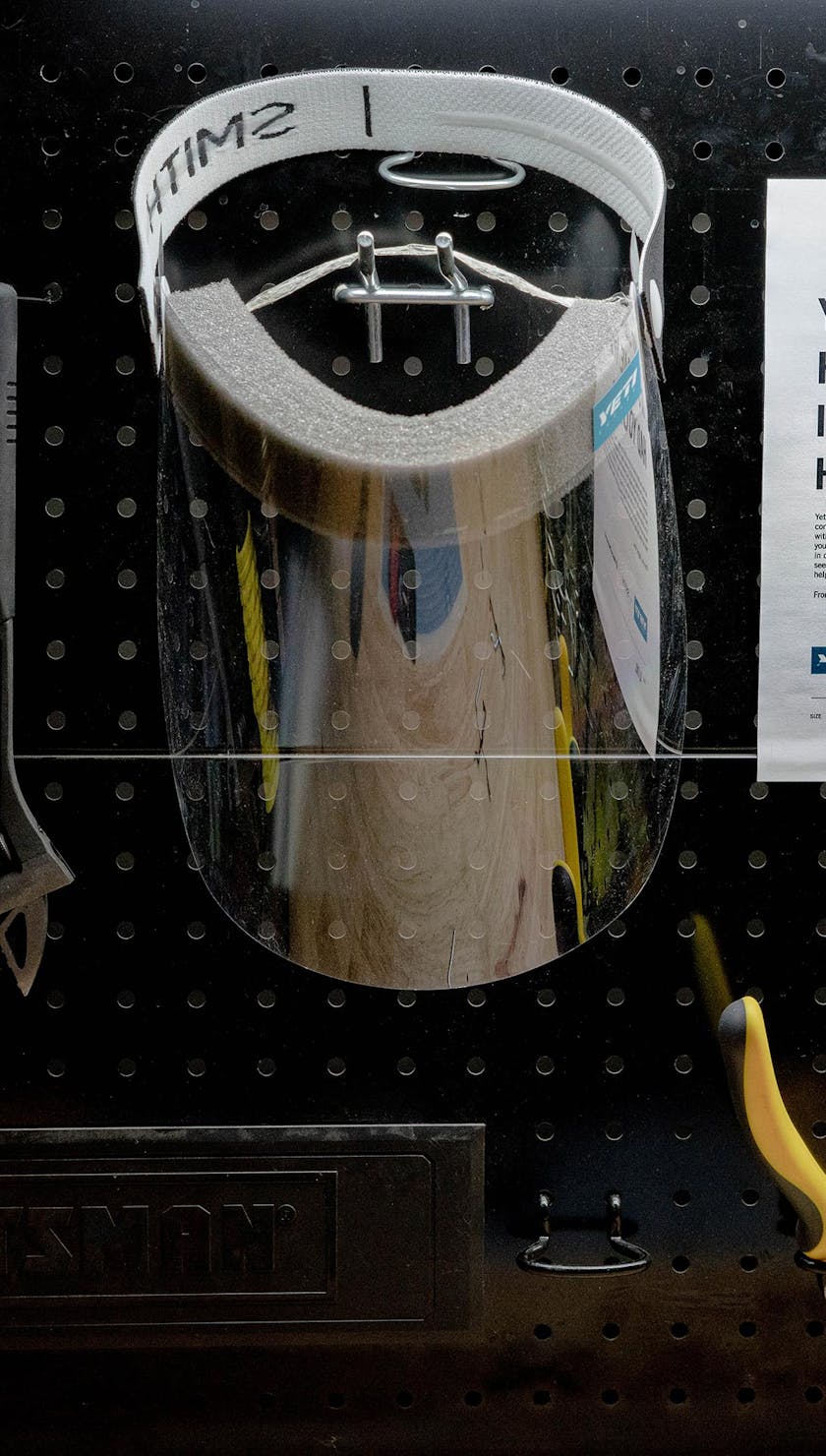 A shield next to tools on a peg board
